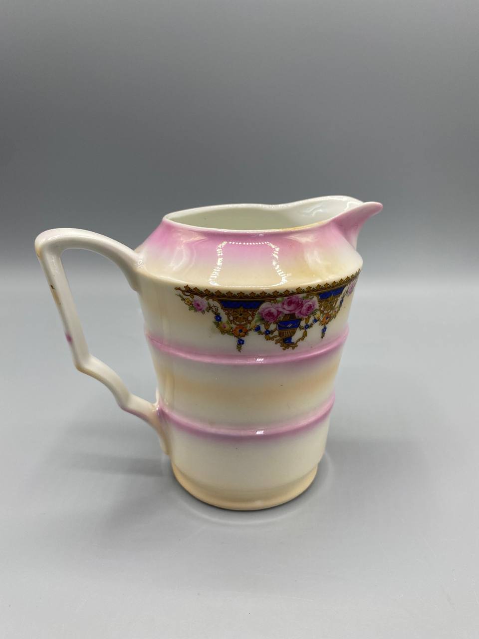 Pot à lait porcelaine fine, vue de dos, anse rectangulaire, décor continu guirlandes et rinceaux dorés