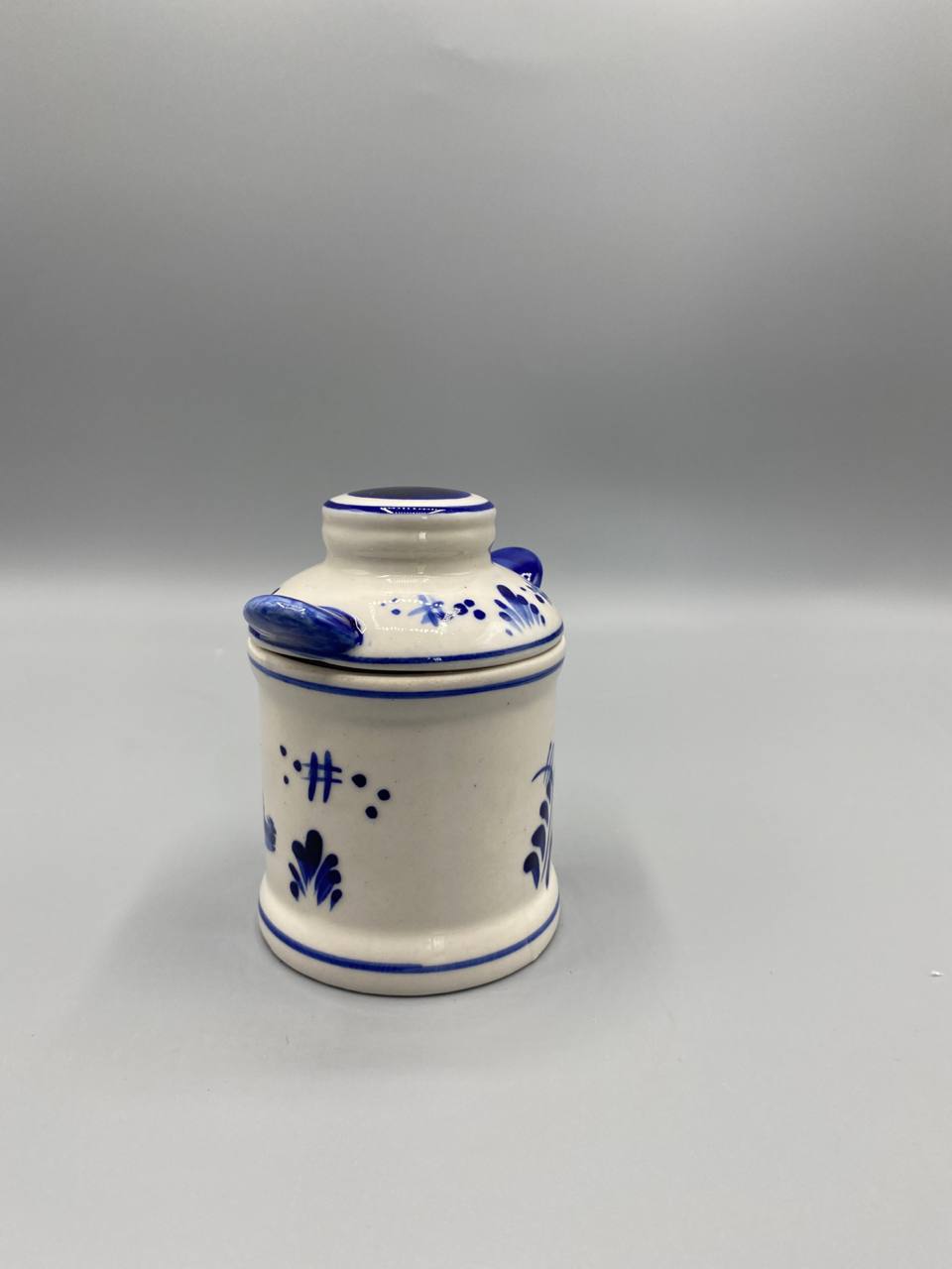 Pot couvert Vero Ceramics, vue de trois quarts, motifs floraux stylisés et personnage en costume hollandais, filets bleus