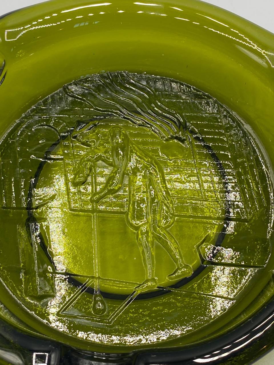 Gros plan médaillon central, souffleur de verre penché devant son four, canne de verrier, décor Art déco en relief