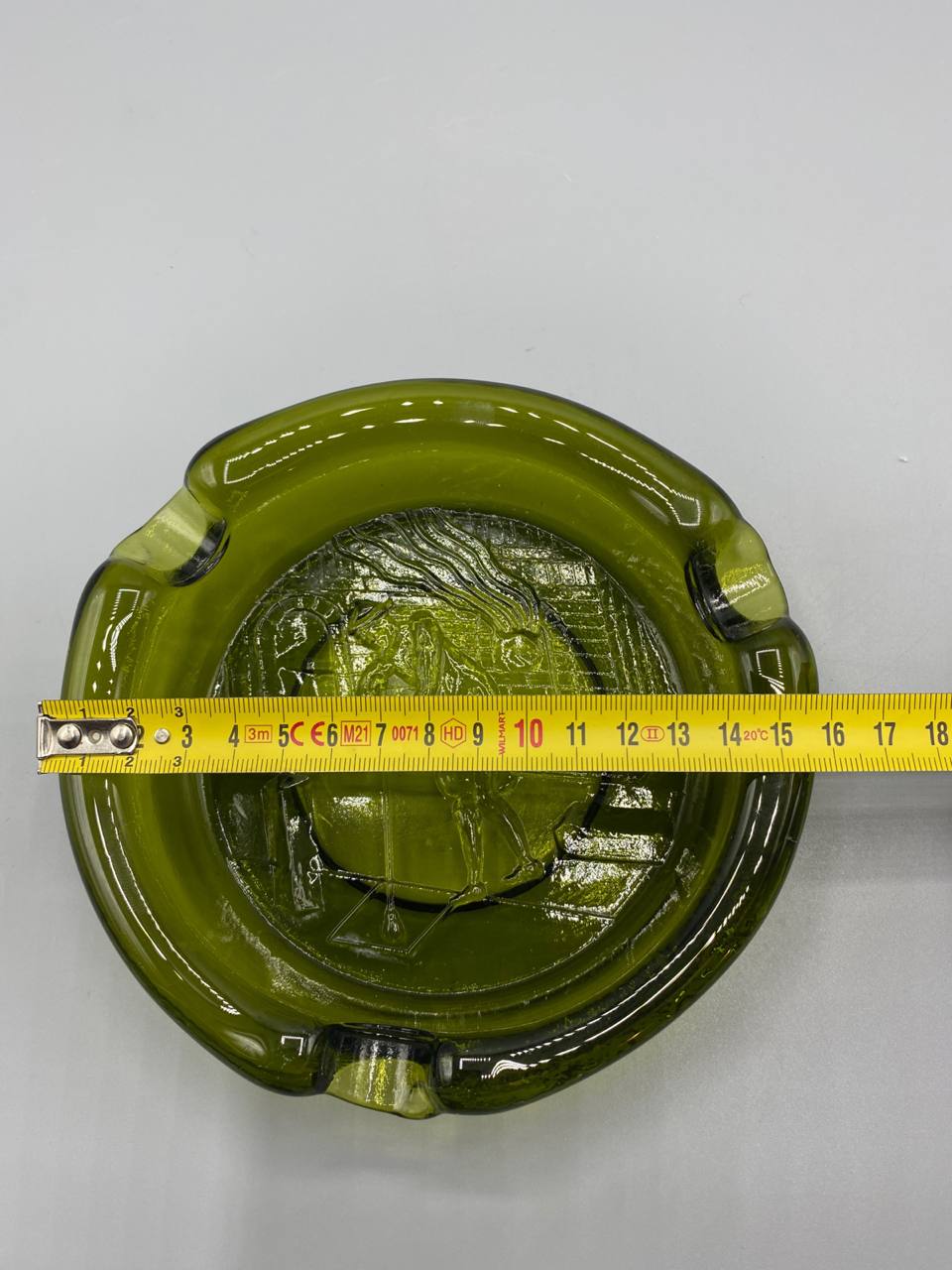 Cendrier verre vert olive avec mètre ruban, diamètre environ 15 cm, vue de dessus