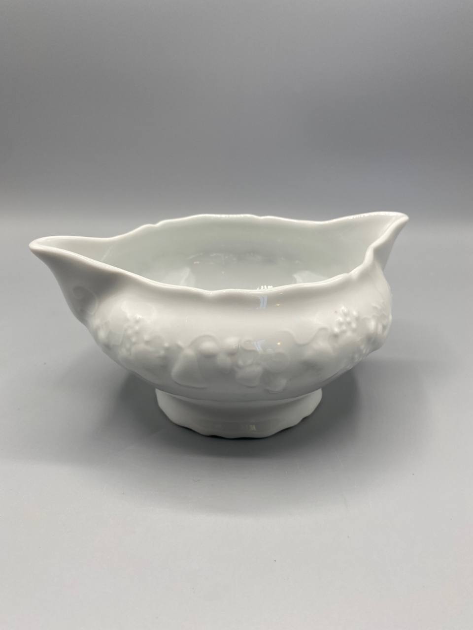 Bol à bouillon porcelaine blanche, vue de face, deux oreilles verseuses, décor relief guirlande fruits et feuillages