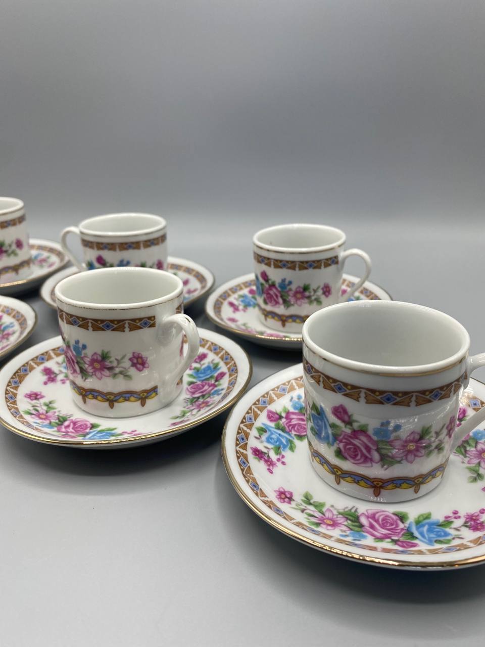 Vue de trois quarts 6 tasses et sous-tasses Jie Pai, porcelaine blanche fine, décor romantique roses et feuillages