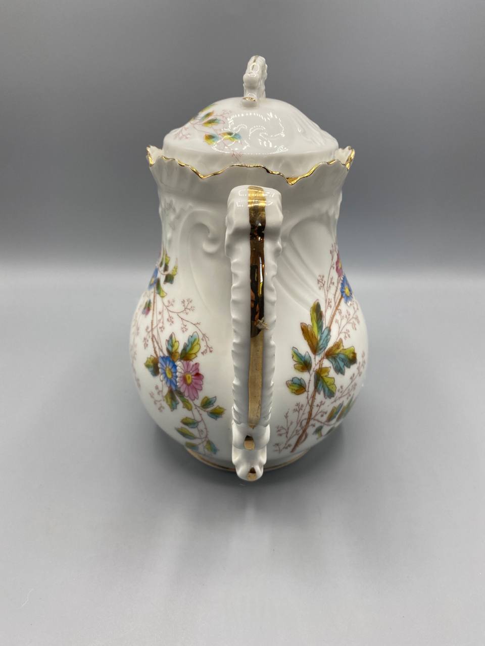Cafetière, vue de dos, anse à double volute moulée, godrons en relief sur la panse, liseré doré sur le col