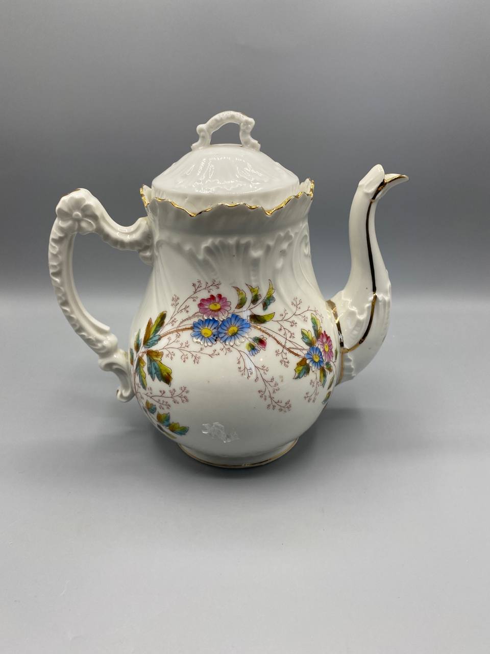 Cafetière, vue de trois quarts côté bec, décor floral polychrome sur fond blanc, bec verseur élancé