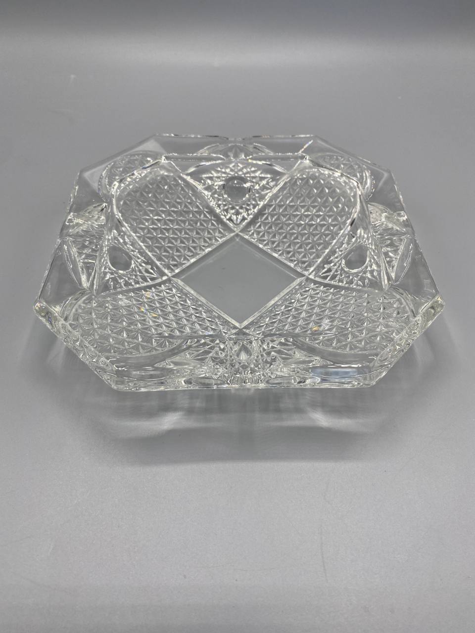 Cendrier carré en cristal pressé moulé, vue de dessus, motif losange central lisse entouré de pointes de diamant en damier, 4 encoches aux angles