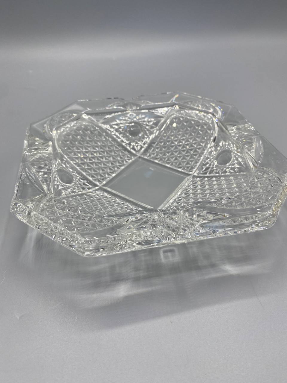 Cendrier cristal, vue de trois quarts, parois à losanges en relief et biseaux à facettes, belle réfraction de la lumière