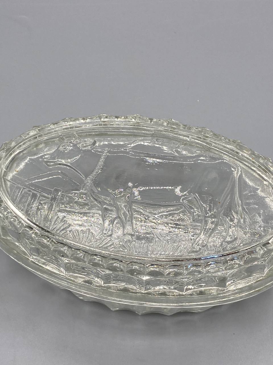 Beurrier verre pressé, vue de face, décor vache et clôture en relief sur le couvercle, belle transparence du verre