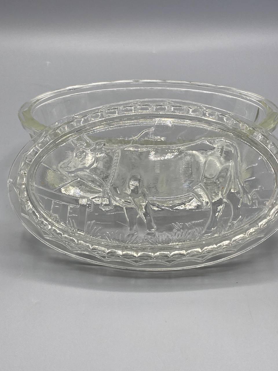 Beurrier verre pressé, vue de profil, couvercle à cloche sur plateau ovale, bord godronné à facettes