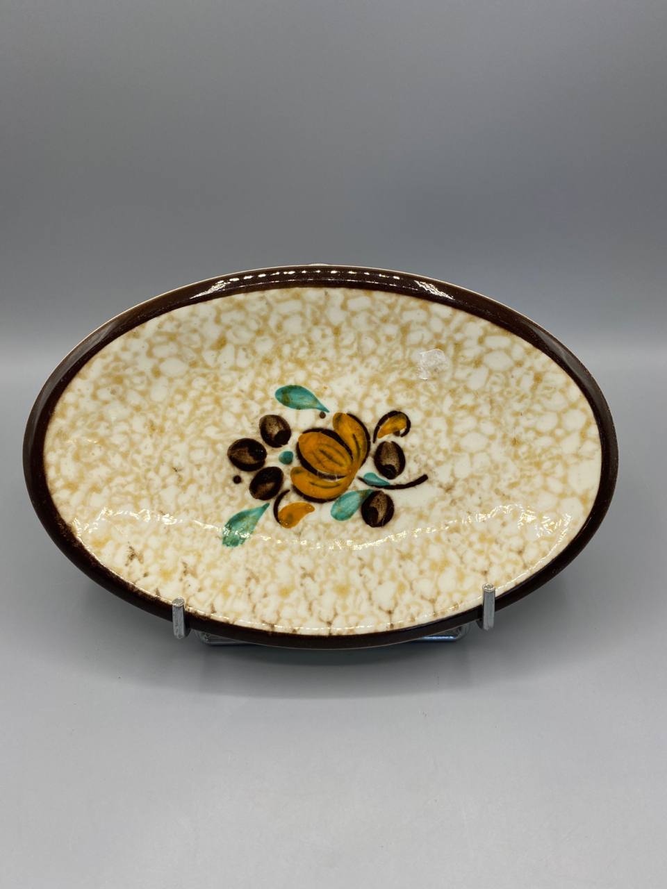 Ravier ovale Boch La Louvière, vue de face, décor Cotton fond moucheté crème, bouquet stylisé ocre vert brun, bordure brun chocolat