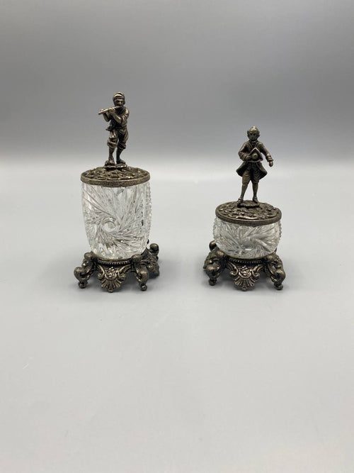 Paire de moutardiers Belle Époque, vue de face, cristal taillé sur socle métal argenté, couvercles figurines joueur de flûte et gentilhomme XVIIIe