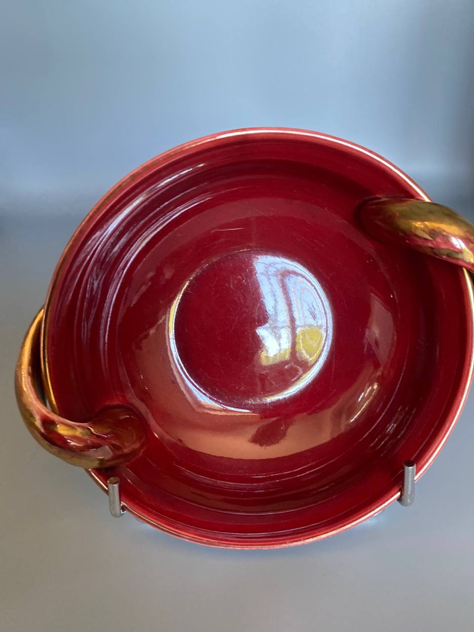 Coupe céramique rouge sang de boeuf, vue de dessus, intérieur rouge profond avec stries de tournage, anses dorées latérales
