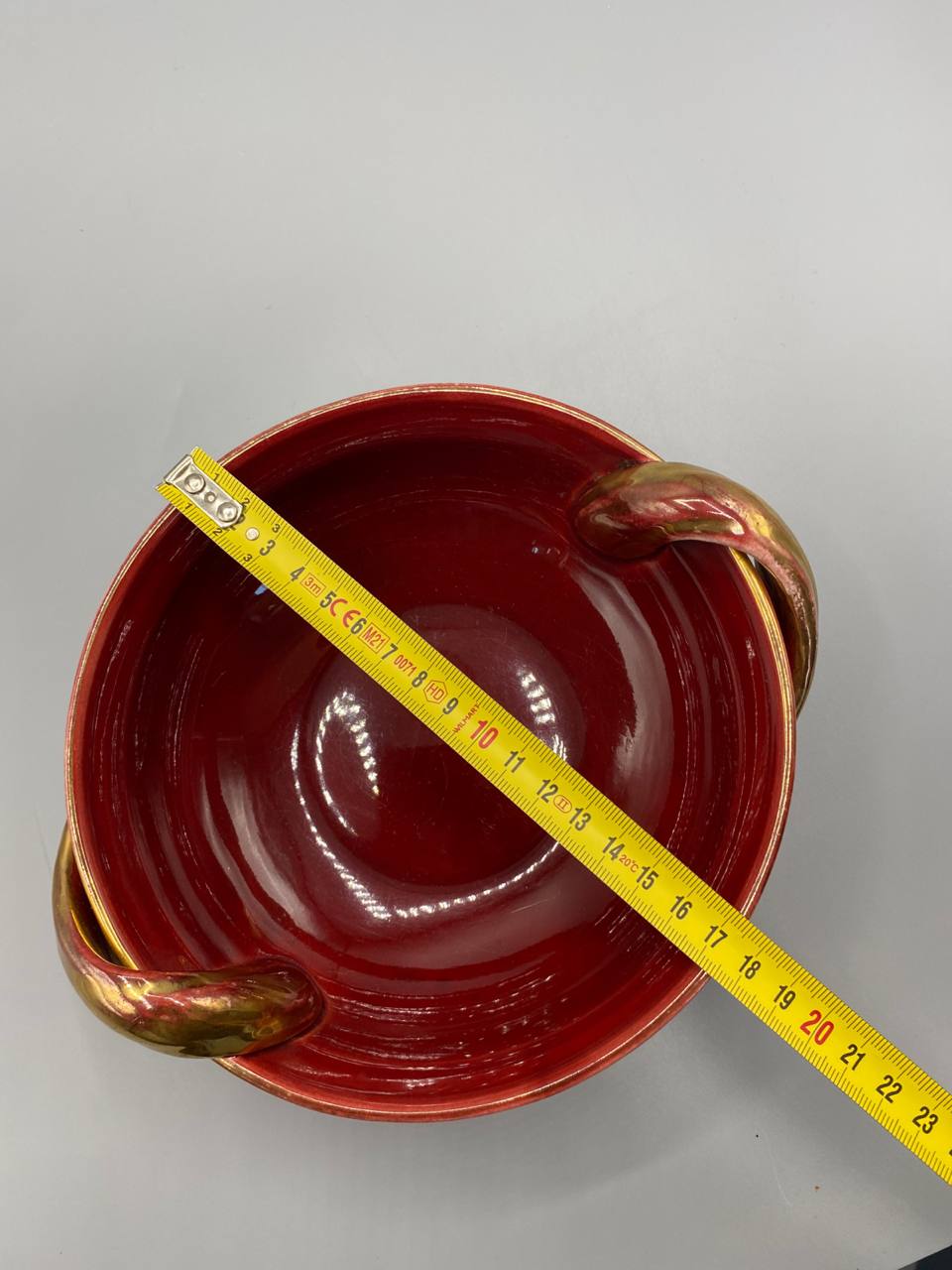 Coupe céramique vue de dessus avec mètre ruban, diamètre intérieur environ 19 cm, émail rouge sang de boeuf brillant