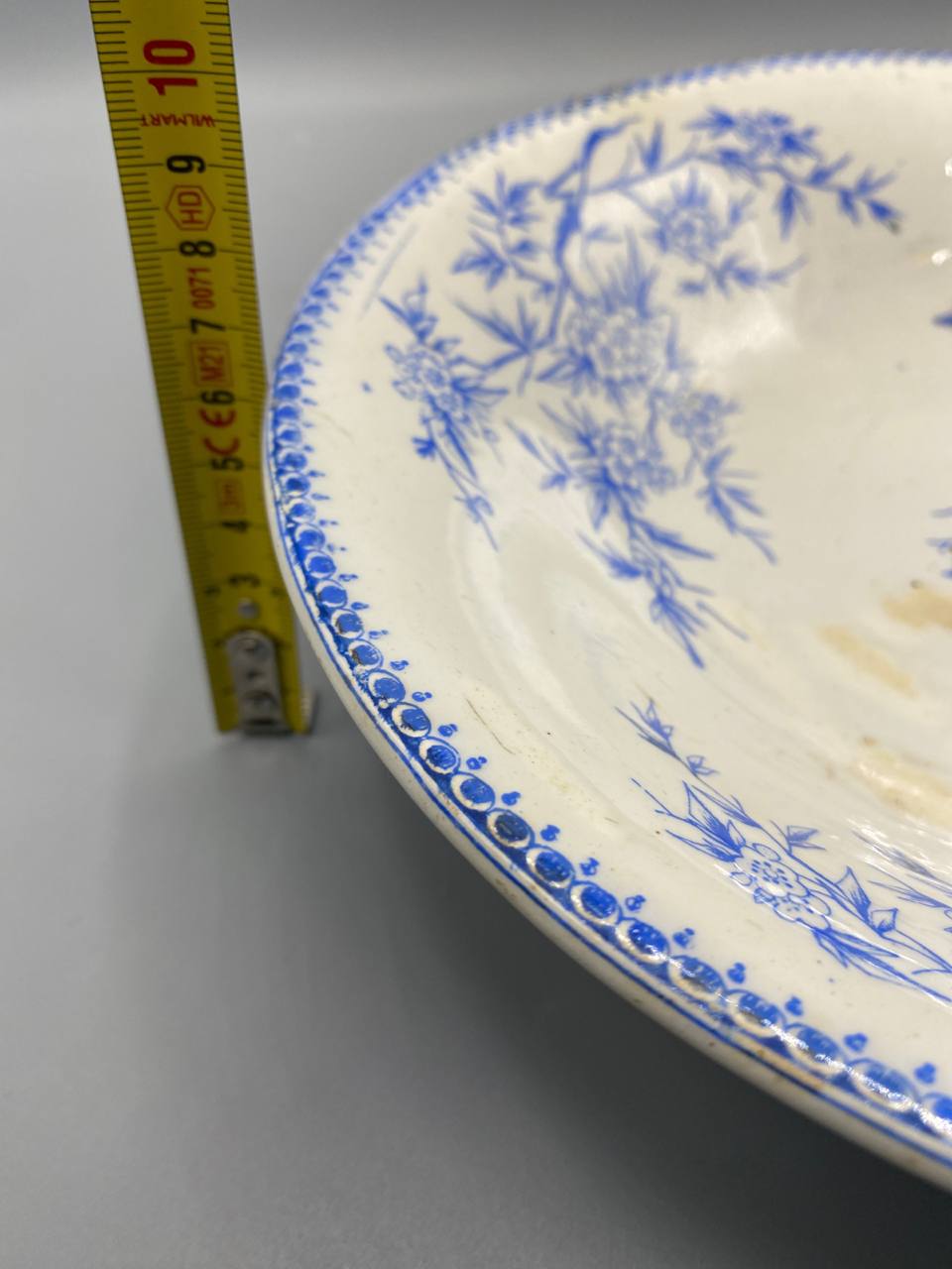 Compotier vu de profil, bord à frise perlée bleue, légère patine d'usage sur le fond ivoire, piédouche annulaire