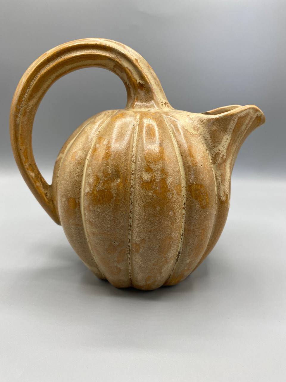 Pichet coloquinte, vue de dos, pied festonné en couronne de pétales, tige de queue de courge en relief sur le dessus, émail ocre irrégulier