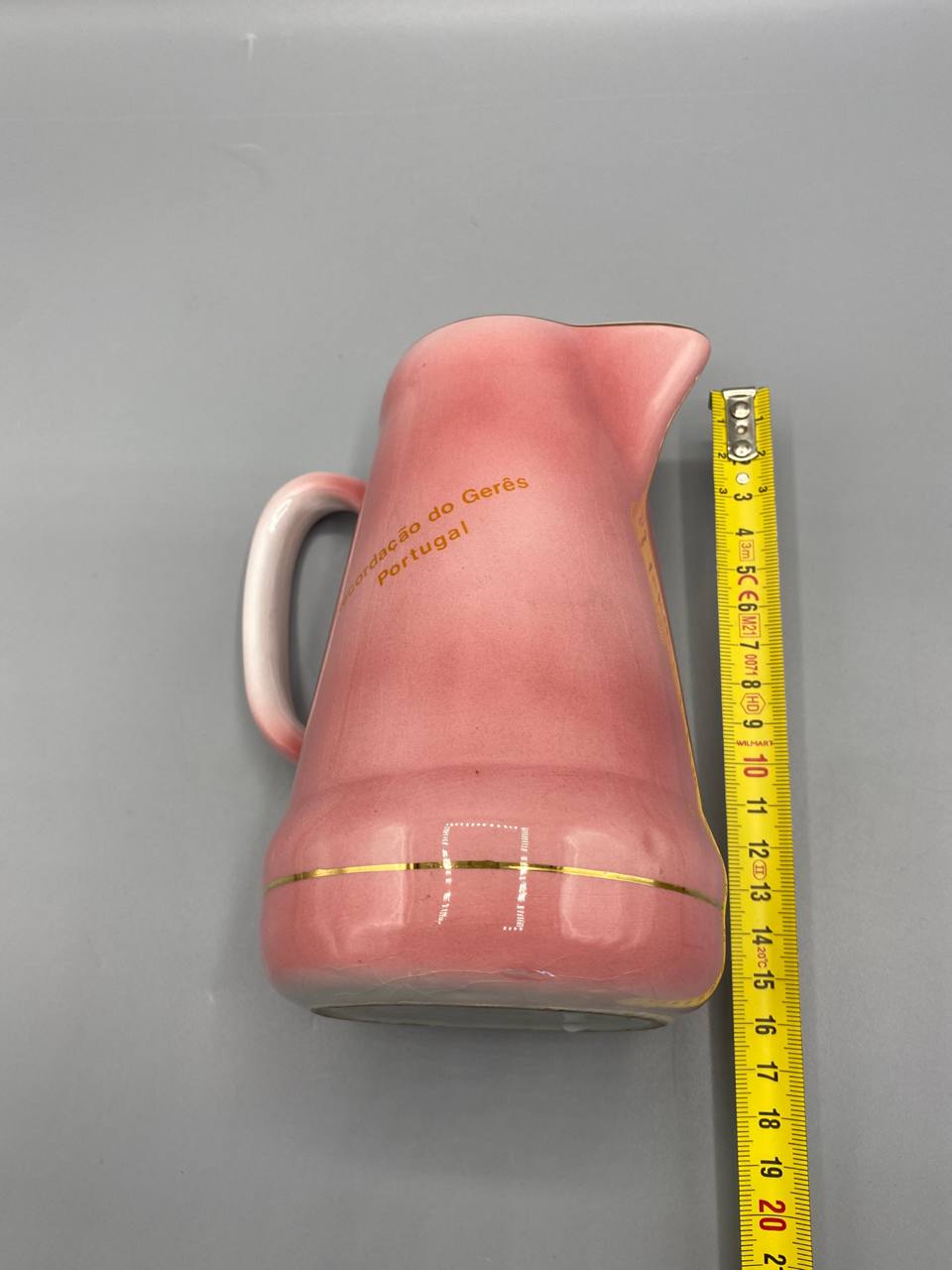 Pichet faïence rose avec mètre ruban, hauteur environ 13 cm, vue de profil, inscription dorée Gerês Portugal visible, filet doré à la base