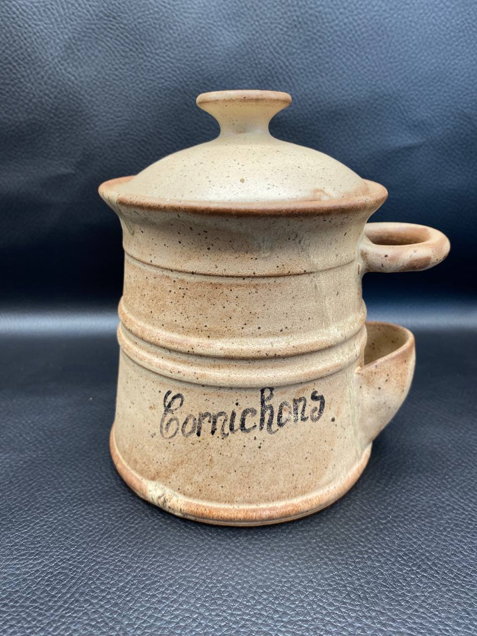 Pot à cornichons grès Vallauris, vue de face avec couvercle, inscription Cornichons en lettres cursives, émail beige sable moucheté, compartiment latéral égouttoir visible