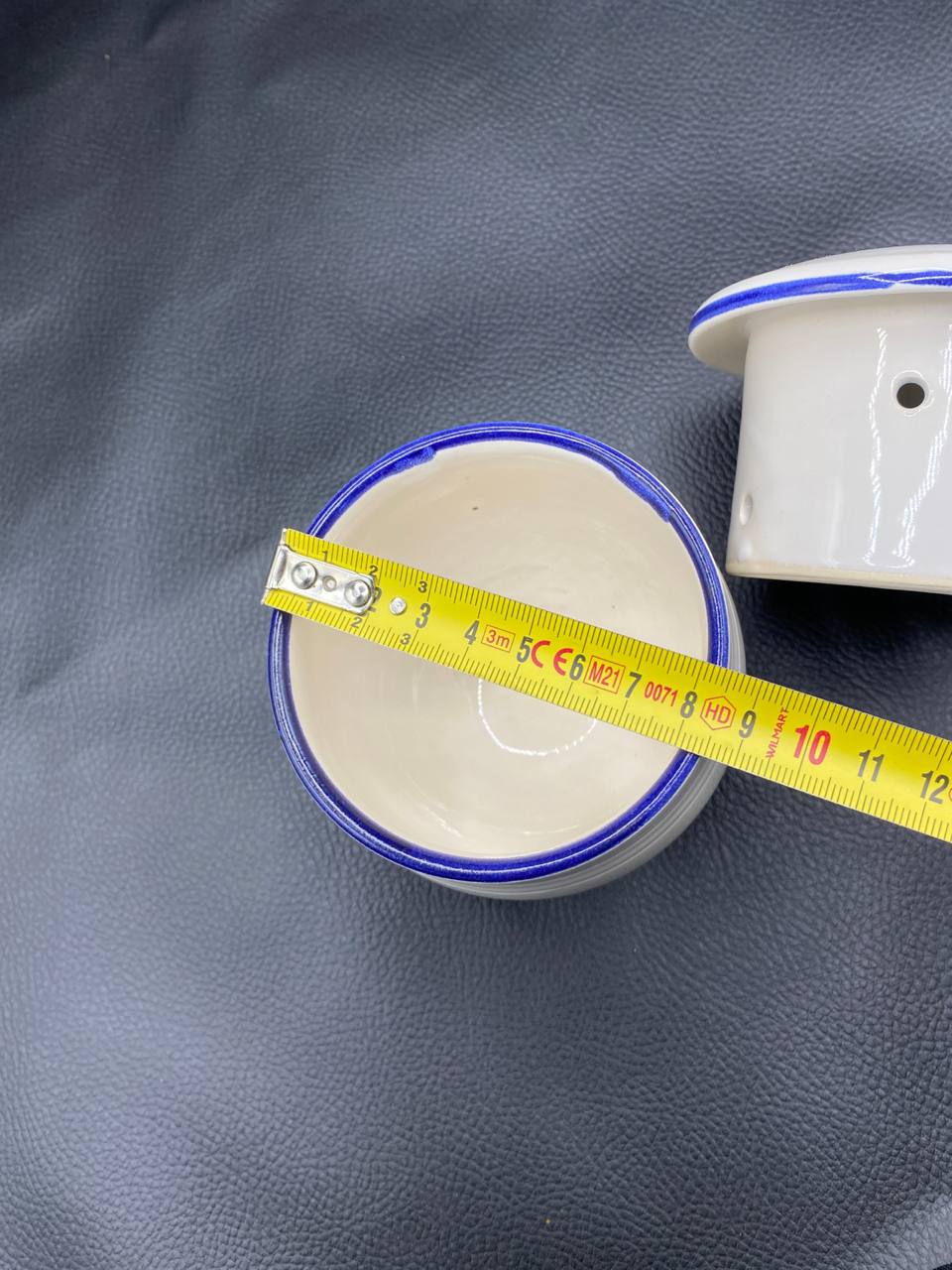 Pot à fromage blanc vu de dessus ouvert avec mètre ruban, diamètre intérieur environ 9 cm, filet bleu cobalt sur le bord, intérieur blanc ivoire brillant