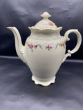 Cafetière Schumann Bavaria, vue de face avec couvercle, silhouette élancée, bec fin, guérilandes florales polychromes sur la panse, reliefs rococo, filets dorés