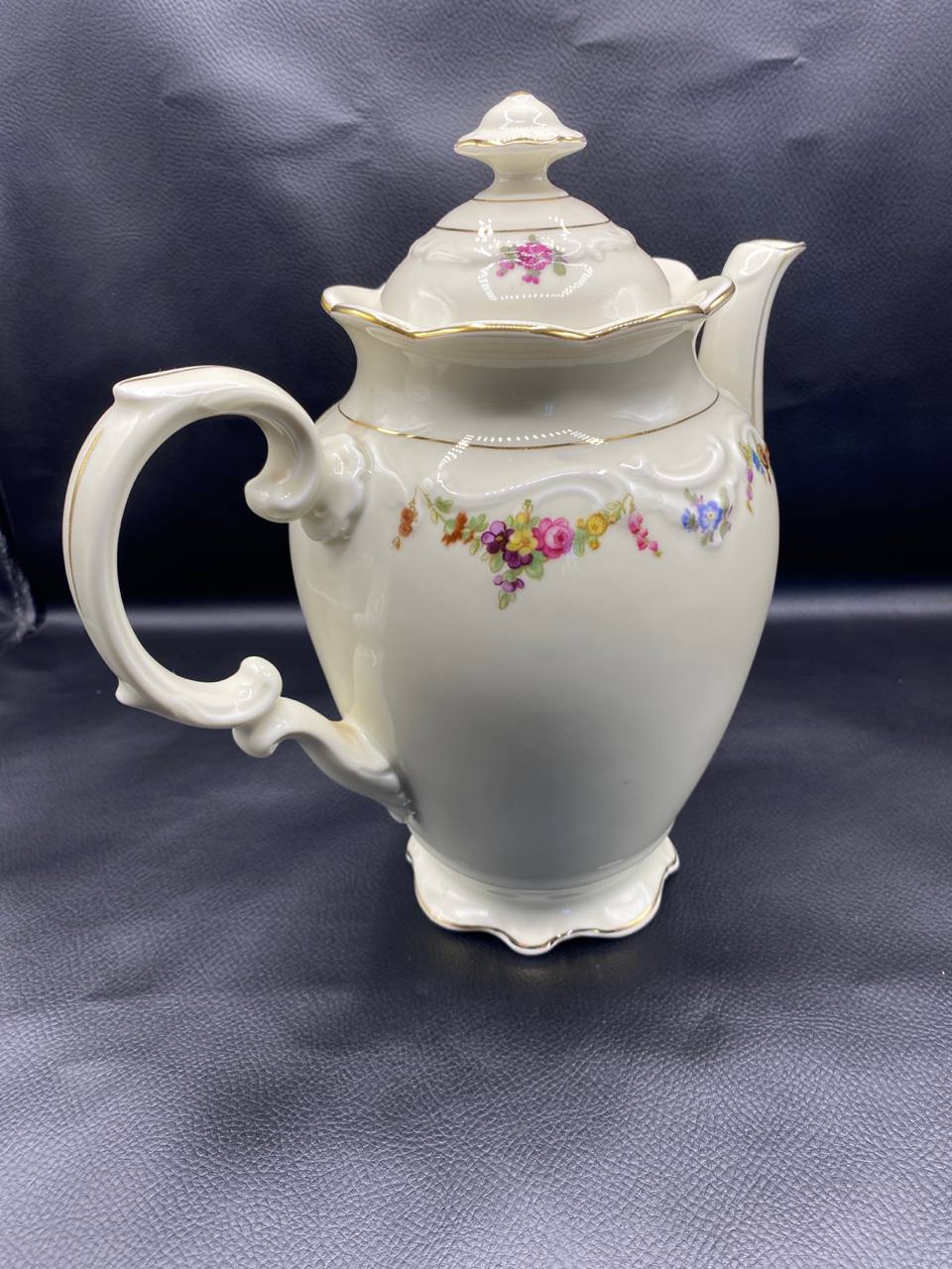 Cafetière Schumann Bavaria, vue de dos côté anse, poignée aux courbes délicates, guérilandes florales roses jaunes bleus violets, reliefs moulés, filets dorés