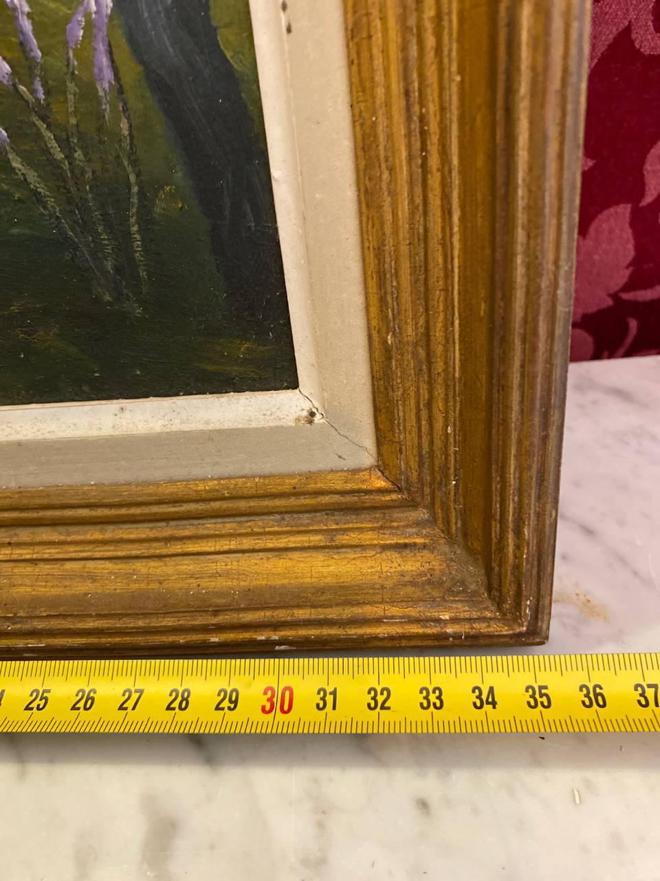 Détail angle inférieur droit du cadre doré cannelé, profil mouluré visible, filet blanc intérieur, surface marbre en dessous