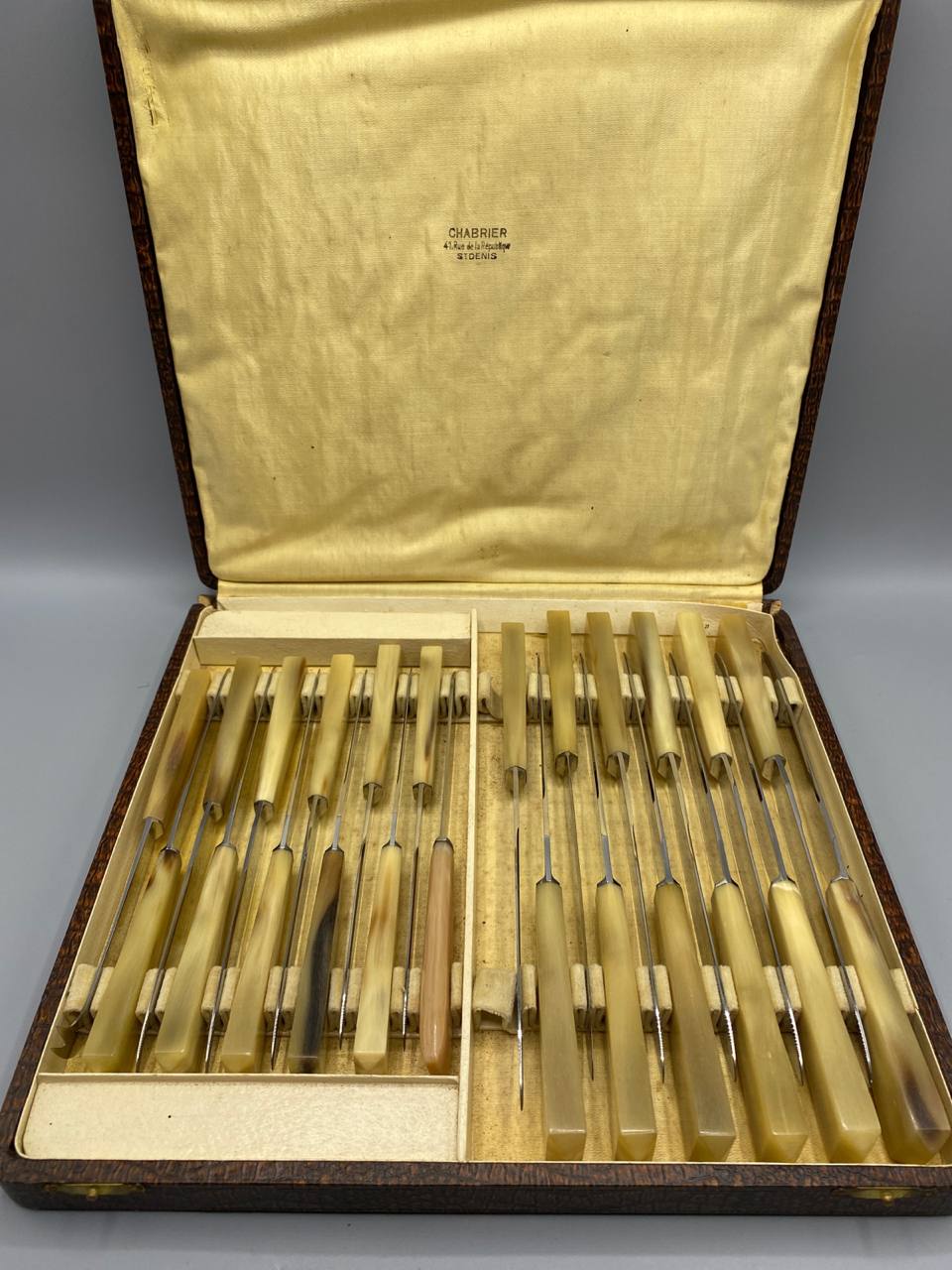 Coffret ouvert de 25 couteaux Chabrier à manches en corne blonde avec estampille dorée