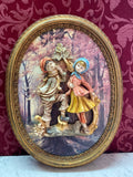 Tableau mural italien en relief, deux enfants en plâtre polychrome dans un cadre ovale doré