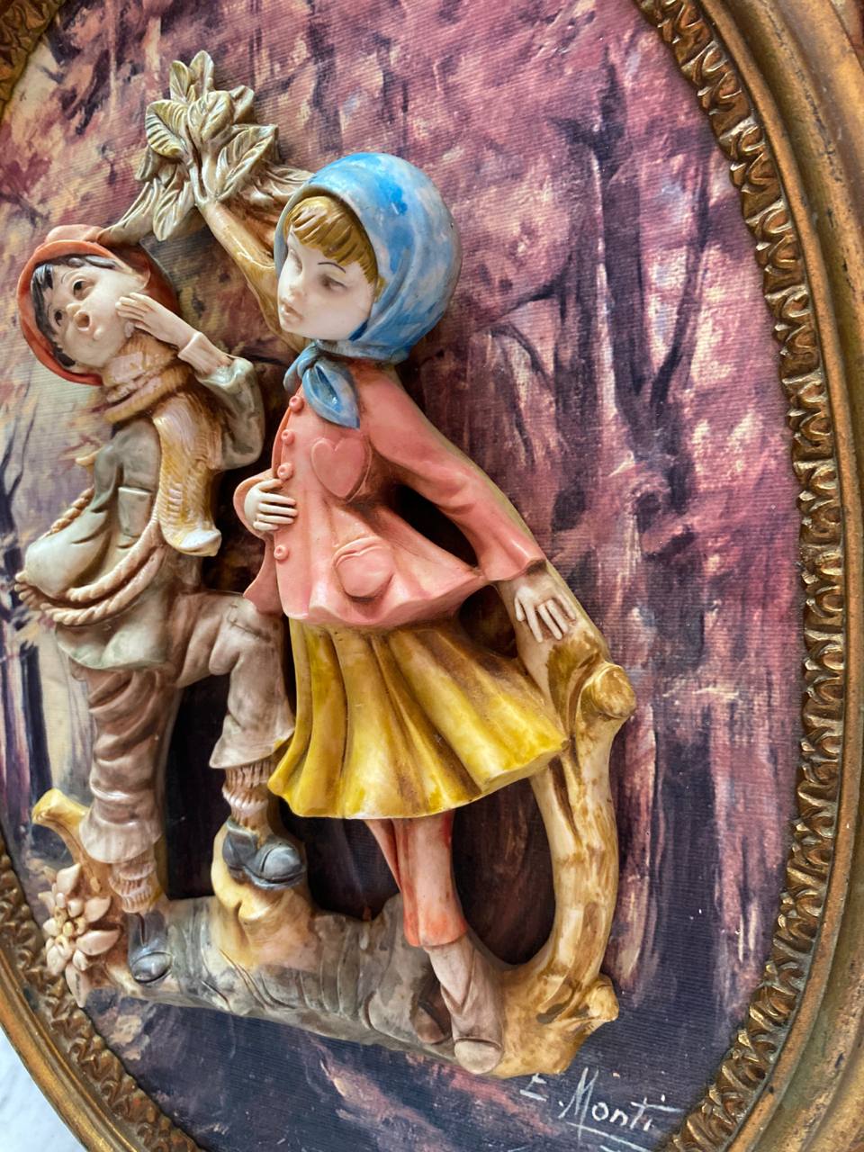 Détail du garçon au bonnet orange et du cadre doré à godrons