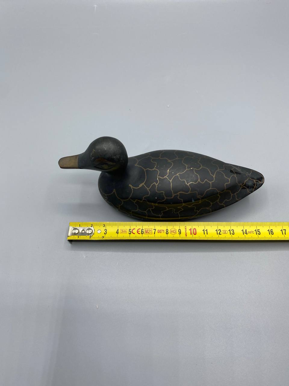 Canard stylisé métal patiné noir doré – vue avec mètre longueur