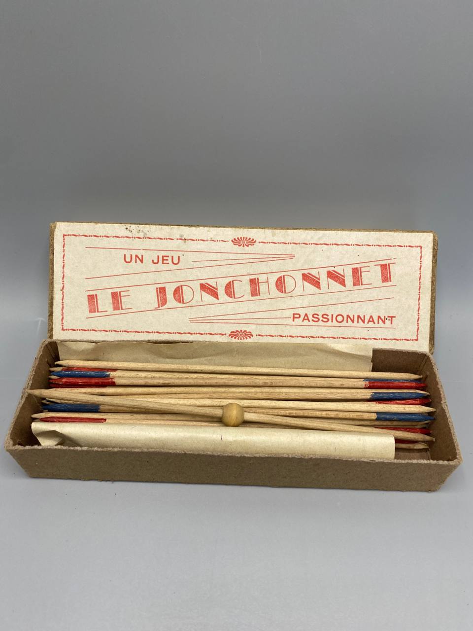 Jeu Le Jonchonnet – boîte ouverte avec jonchets et bille en bois