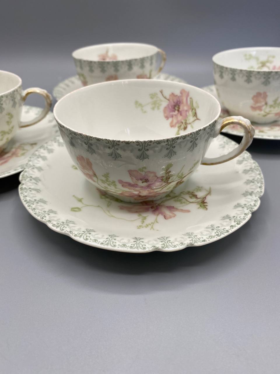 4 tasses et sous-tasses Jean Pouyat Limoges – vue rapprochée, frise rinceaux gris-vert et fleurs roses