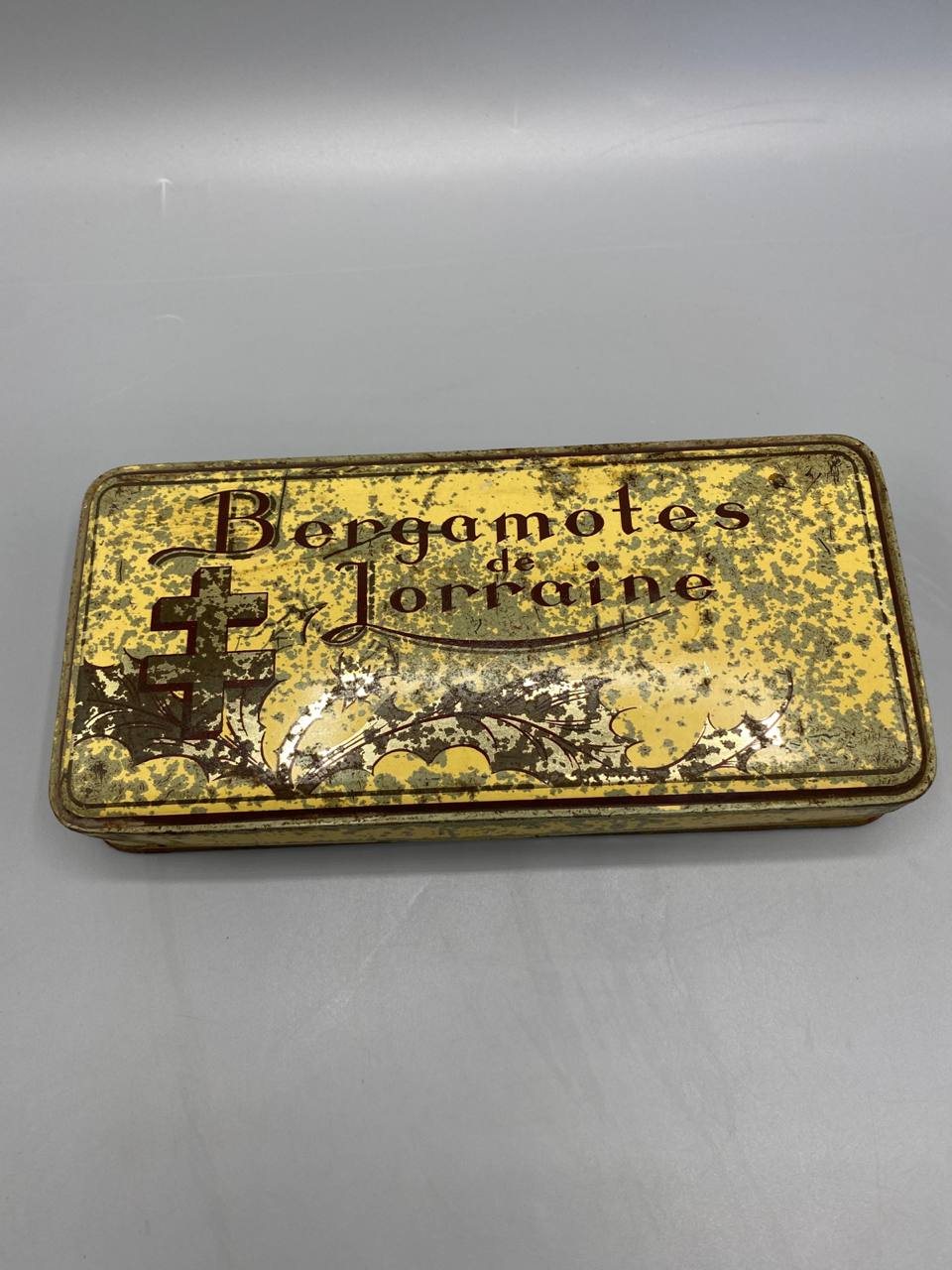 Boîte Bergamotes de Lorraine – couvercle fermé, inscription et croix de Lorraine sur fond jaune moucheté or