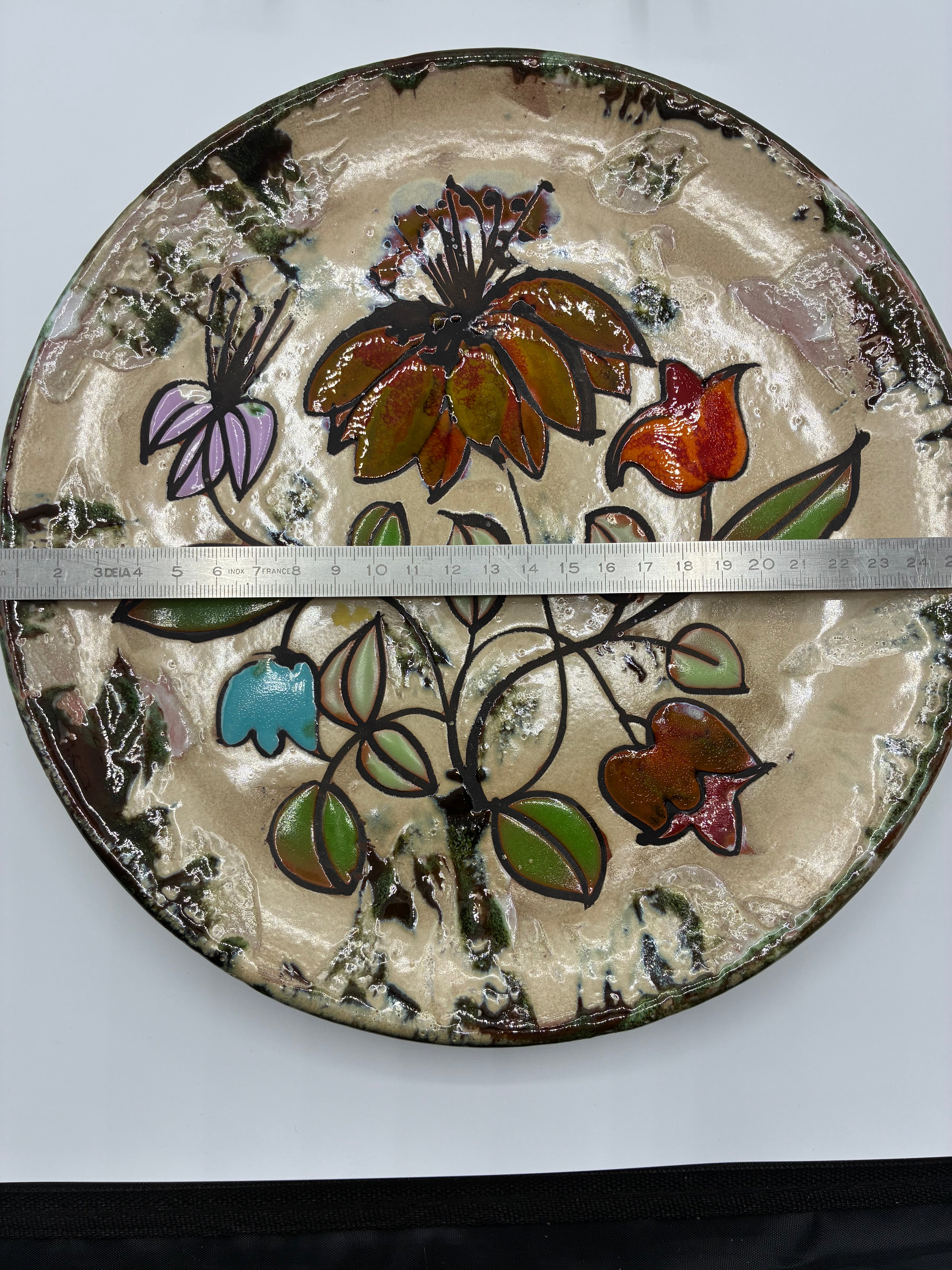 Plat mural en faïence émaillée – Décor floral stylisé polychrome – Production artisanale années 1970