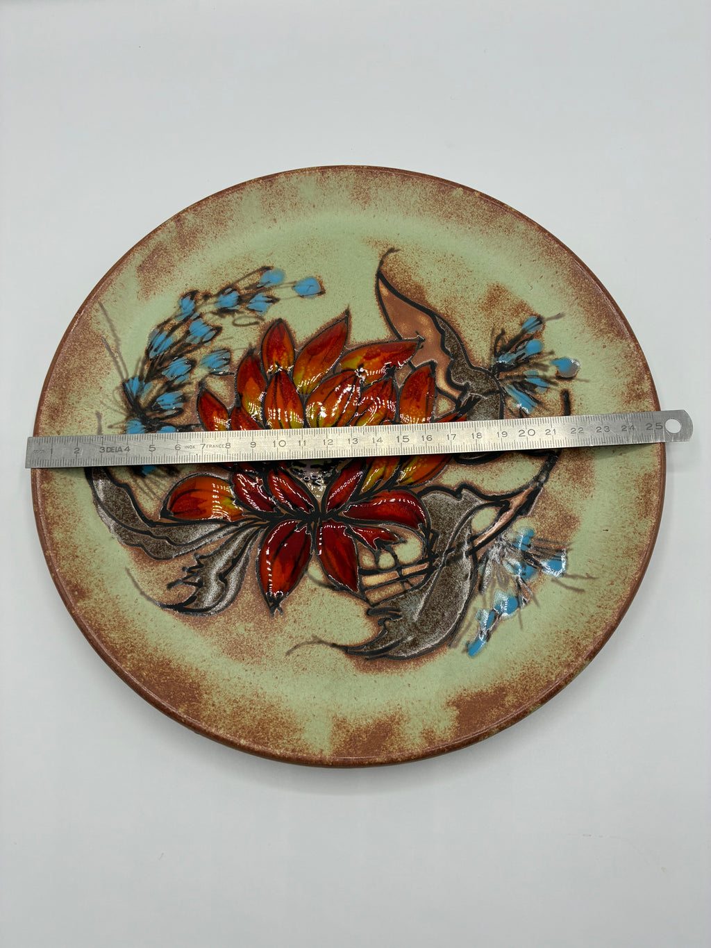 Plat mural céramique de Vallauris – Fleur solaire rouge et orange – Signé La Grange – Années 1960–1970