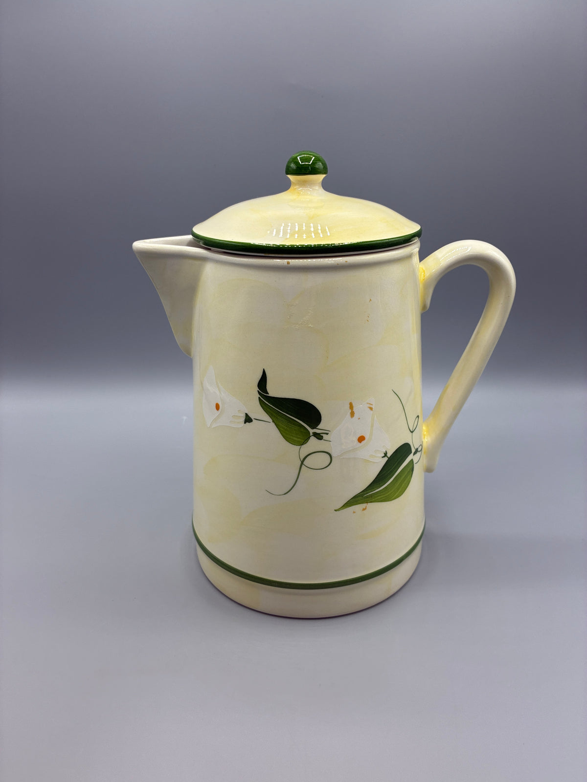 Grande cafetière en faïence crème à décor d’arums blancs et de feuillages verts