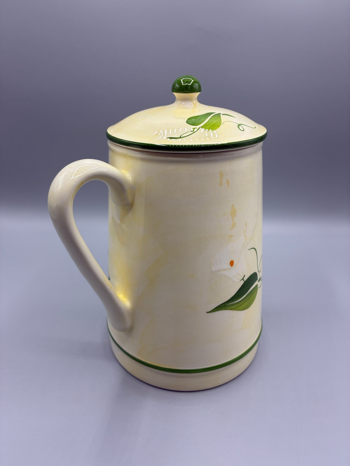 Vue de la cafetière côté anse avec couvercle et bouton vert