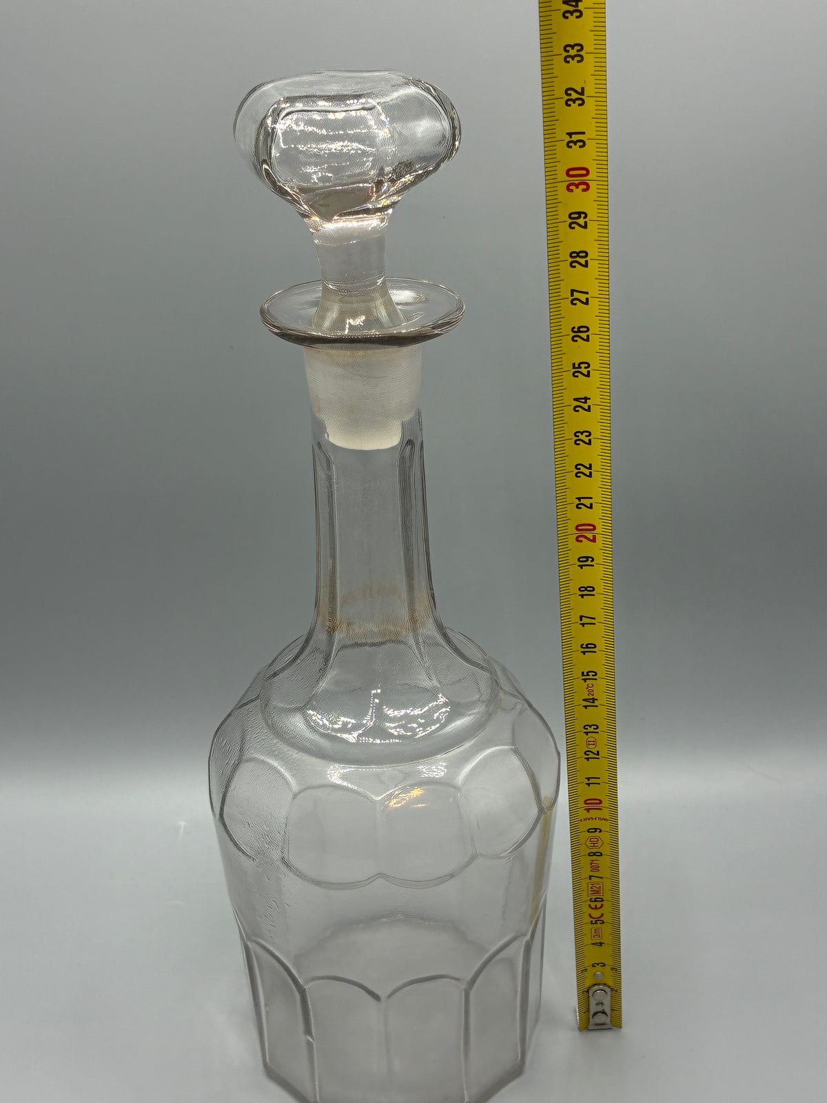 Détail des arcatures moulées et des traces d’usage sur la carafe ancienne
