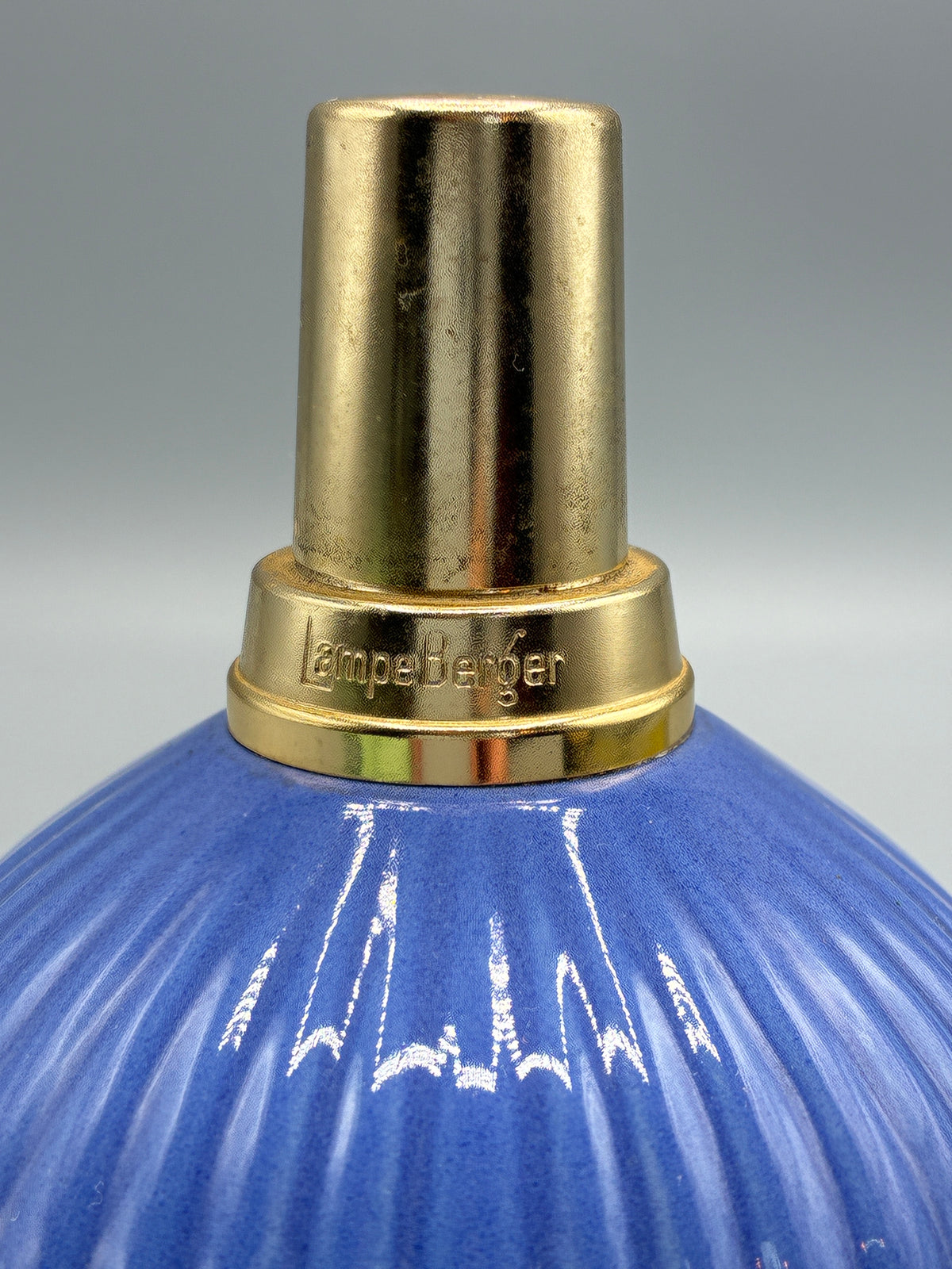 Gros plan sur la monture dorée gravée Lampe Berger de la lampe en céramique bleue