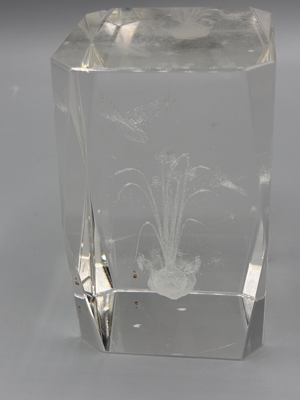 Bloc de cristal facetté montrant le décor gravé de fleurs dans la masse