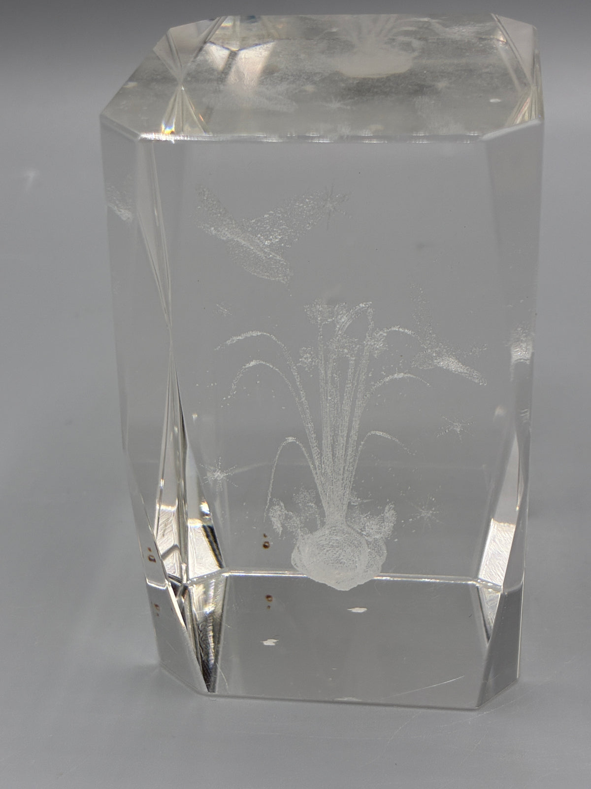 Bloc de cristal facetté montrant le décor gravé de fleurs dans la masse