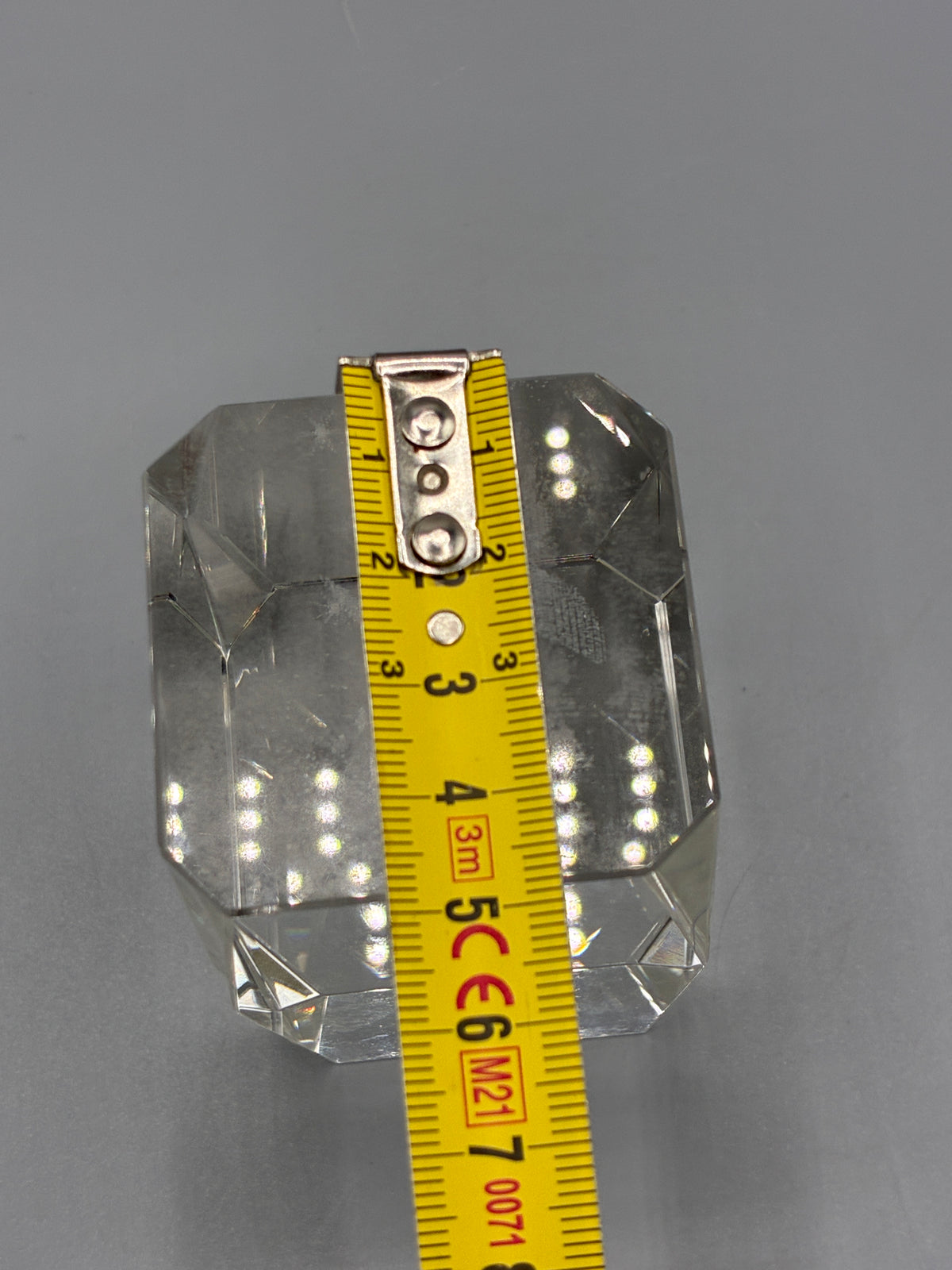 Largeur du bloc de cristal facetté mesurée au mètre ruban, environ 6 cm