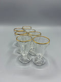 Ensemble de sept verres à liqueur facettés en verre transparent à bord doré