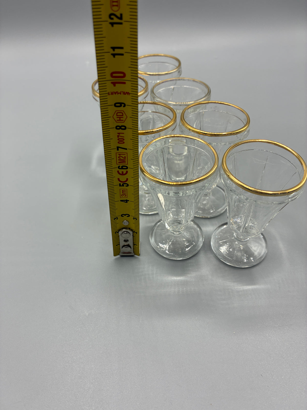 Sept verres à liqueur vus du dessus avec leurs bordures dorées