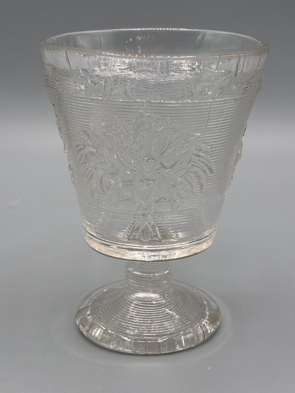 Verre à pied ancien en verre moulé transparent à décor floral et strié