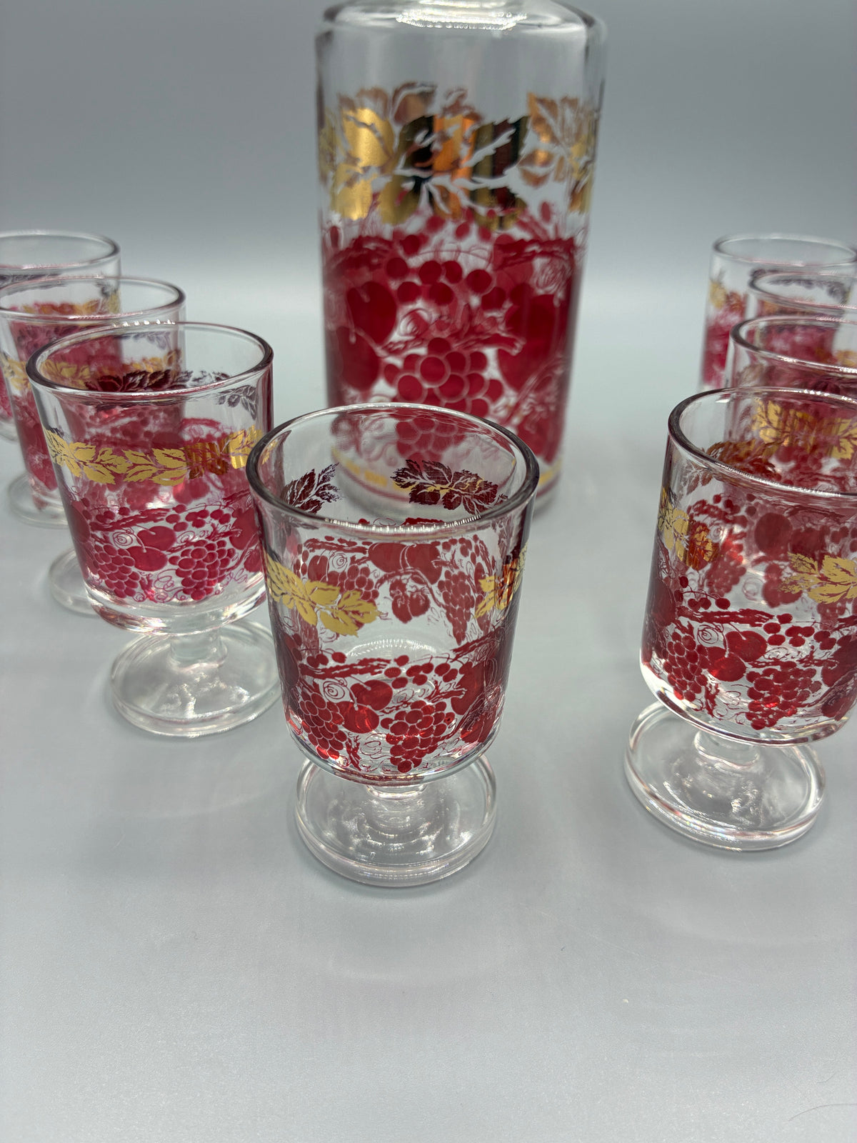 Service à liqueur vintage, carafe et huit verres à pied rouge et or