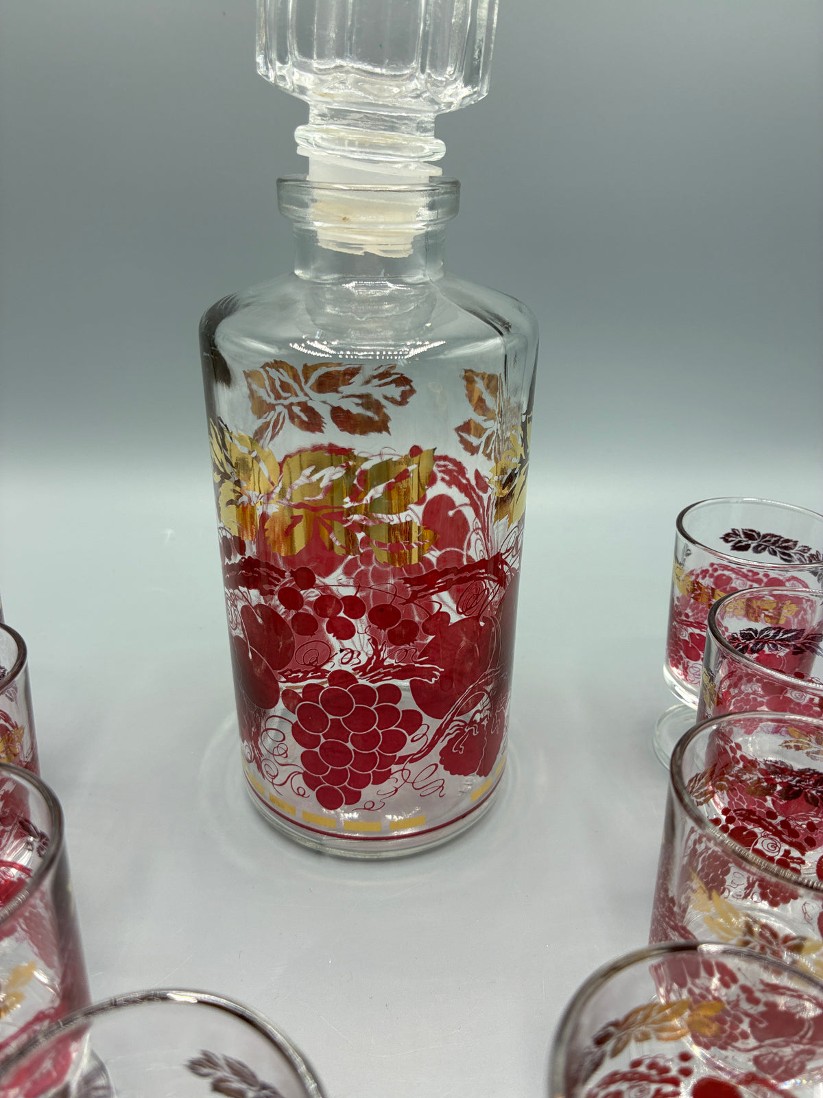 Détail des verres à pied au décor de vigne rouge et or