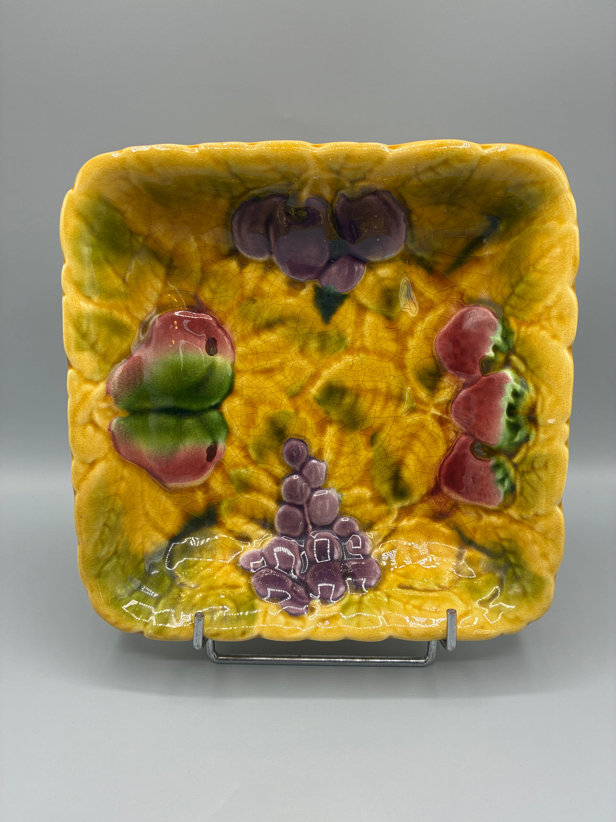 Détail des raisins violets et fruits sur la glaçure jaune craquelée