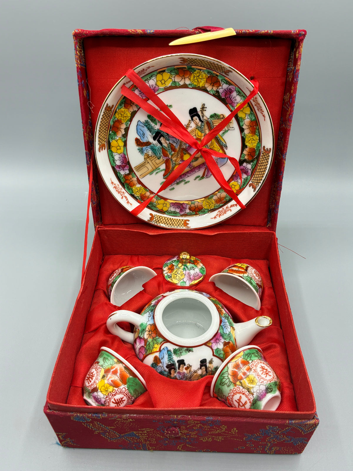 Coffret d’origine fermé, habillé de tissu rouge à motifs asiatiques