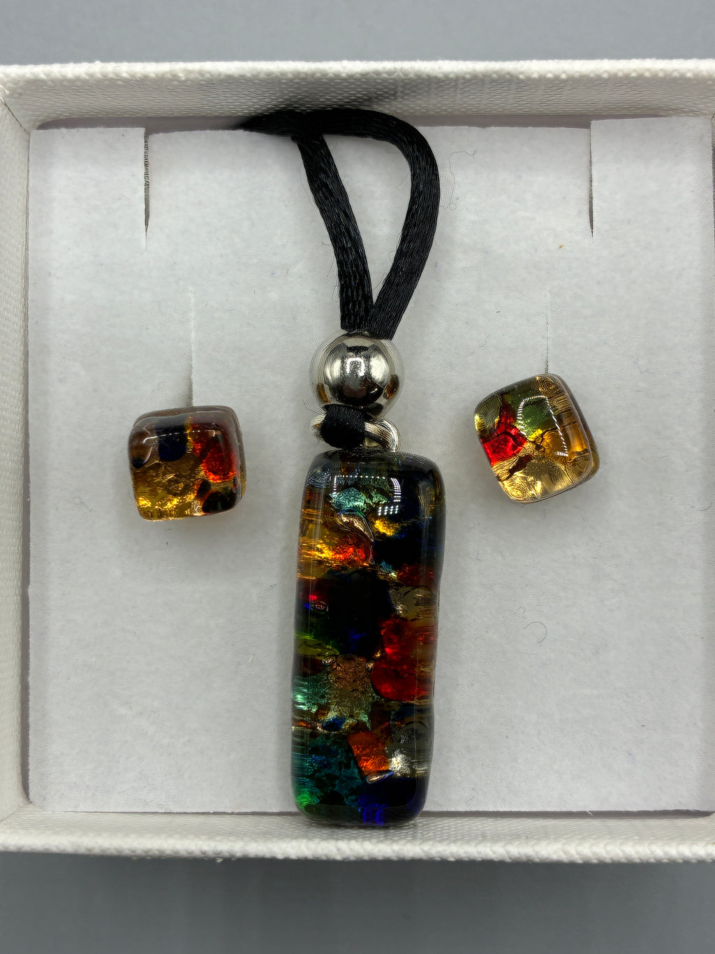 Collier Murano sur cordon noir présenté sur buste avec ses boucles d’oreilles assorties en écrin