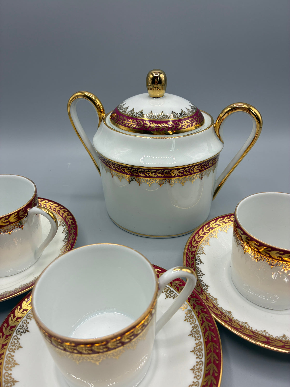 Détail d’une tasse à café et de sa soucoupe à frise pourpre et lauriers dorés
