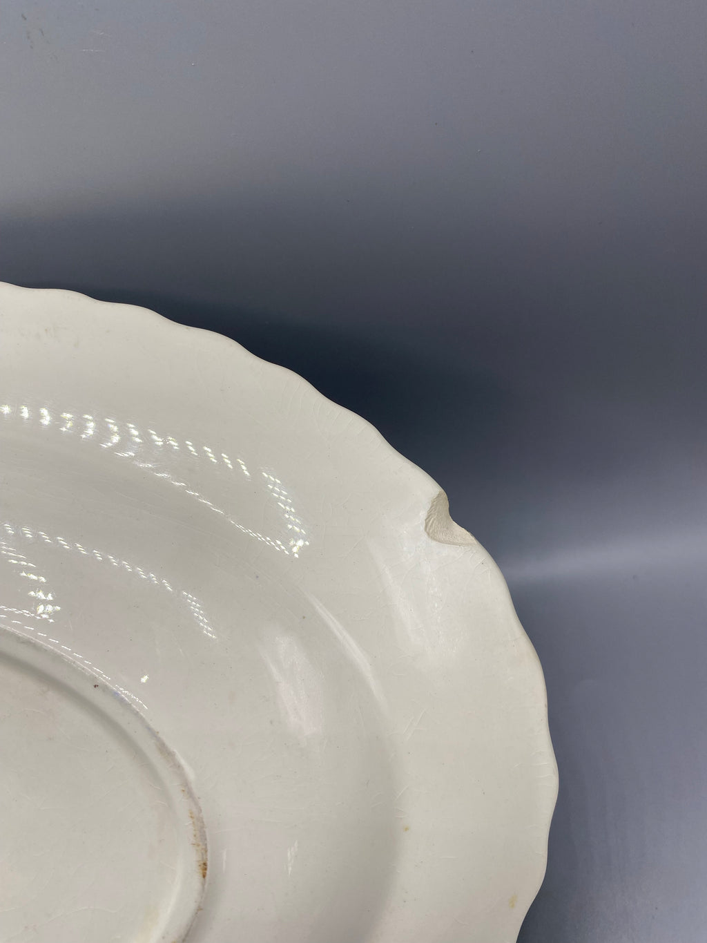 Grand plat faience hollandaise C&S Rotterdam, detail eclat avec manque sur le bord